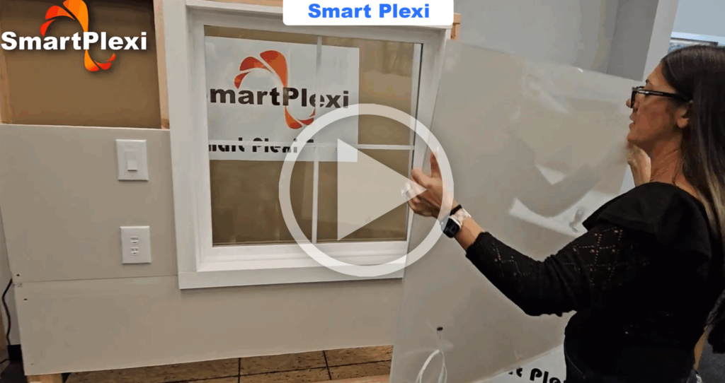 Woman in black holds up a clear protective panel in front of a window display labeled Smart Plexi.